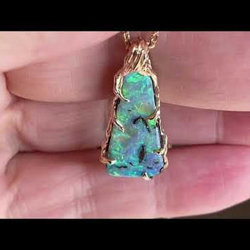 Vedhæng med en ægte solid boulder opal fra Australien indfattet i 14 karat rustikt guld. De krogede rustikke grene af 14 karat guld holder opalen på plads.