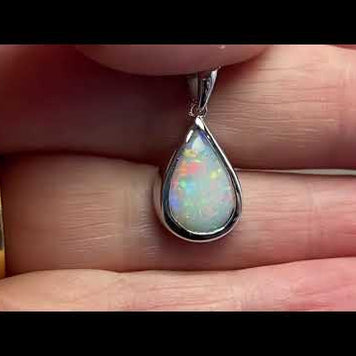 Vedhæng med en ægte solid krystal opal fra Australien indfattet i blankt rhodineret sterling sølv.