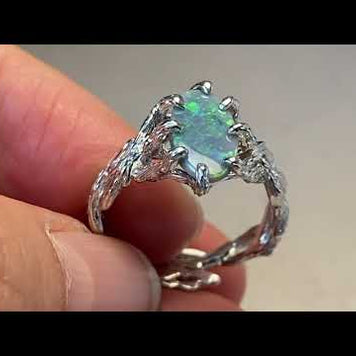 Ring med ægte solid opal fra Australien. Opalen er indfattet i rustikt sterling sølv. Krogede rustikke grene af sterling sølv holder opalen på plads.