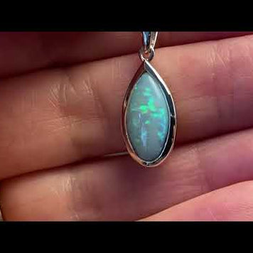 Vedhæng med en ægte solid krystal opal fra Australien indfattet i rhodineret sterling sølv.
