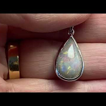 Vedhæng med en ægte solid krystal opal fra Australien indfattet i blankt rhodineret sterling sølv.