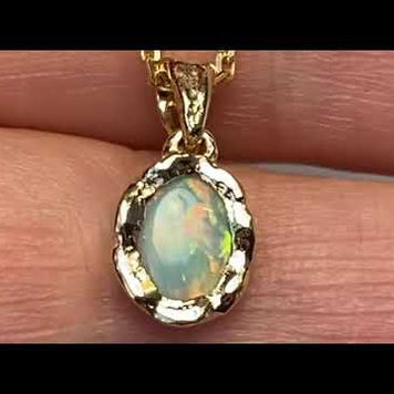 Vedhæng med en ægte solid krystal opal fra Australien indfattet i et rustikt vedhæng med organiske former i 14 karat guld.