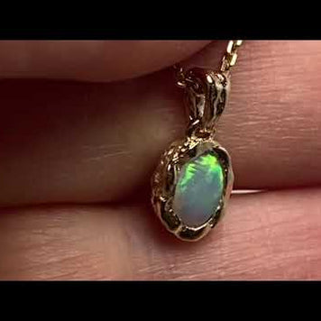 Vedhæng med en ægte solid krystal opal fra Australien indfattet i et rustikt vedhæng med organiske former i 14 karat guld.
