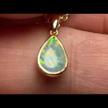 Vedhæng med en ægte solid krystal opal fra Australien indfattet i 14 karat guld.
