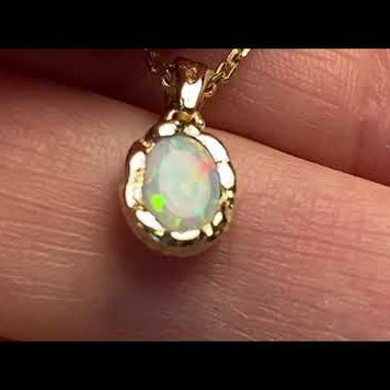Vedhæng med en ægte solid krystal opal fra Australien indfattet i et rustikt vedhæng med organiske former i 14 karat guld.