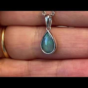 Vedhæng med en ægte solid krystal opal fra Australien indfattet i blankt sterling sølv.