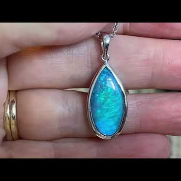 Vedhæng med en ægte solid krystal opal fra Australien indfattet i rhodineret sterling sølv.