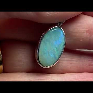 Vedhæng med en ægte solid krystal opal fra Australien indfattet i blankt rhodineret sterling sølv.