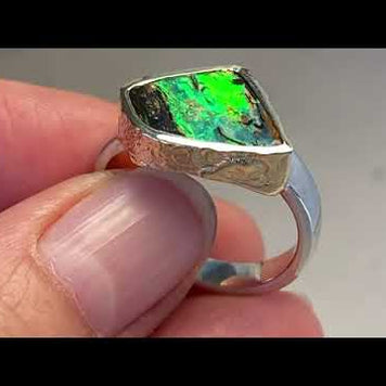 Ring med ægte solid boulder opal fra Australien indfattet i 14 karat rustikt guld og ringskinnen er lavet af blankt sterling sølv.
